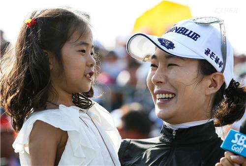 안시현(오른쪽)이 한국여자오픈에서 우승한 뒤 딸 그레이스(왼쪽)를 안고 환하게 웃고 있다.