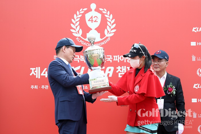 박현경(오른쪽)이 마스크와 라텍스 장갑을 착용하고 우승 트로피를 받고 있다.